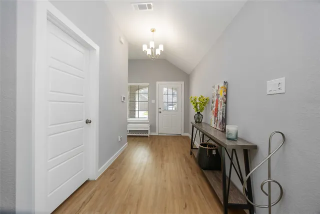 a view of a hallway with wooden floor and staircase