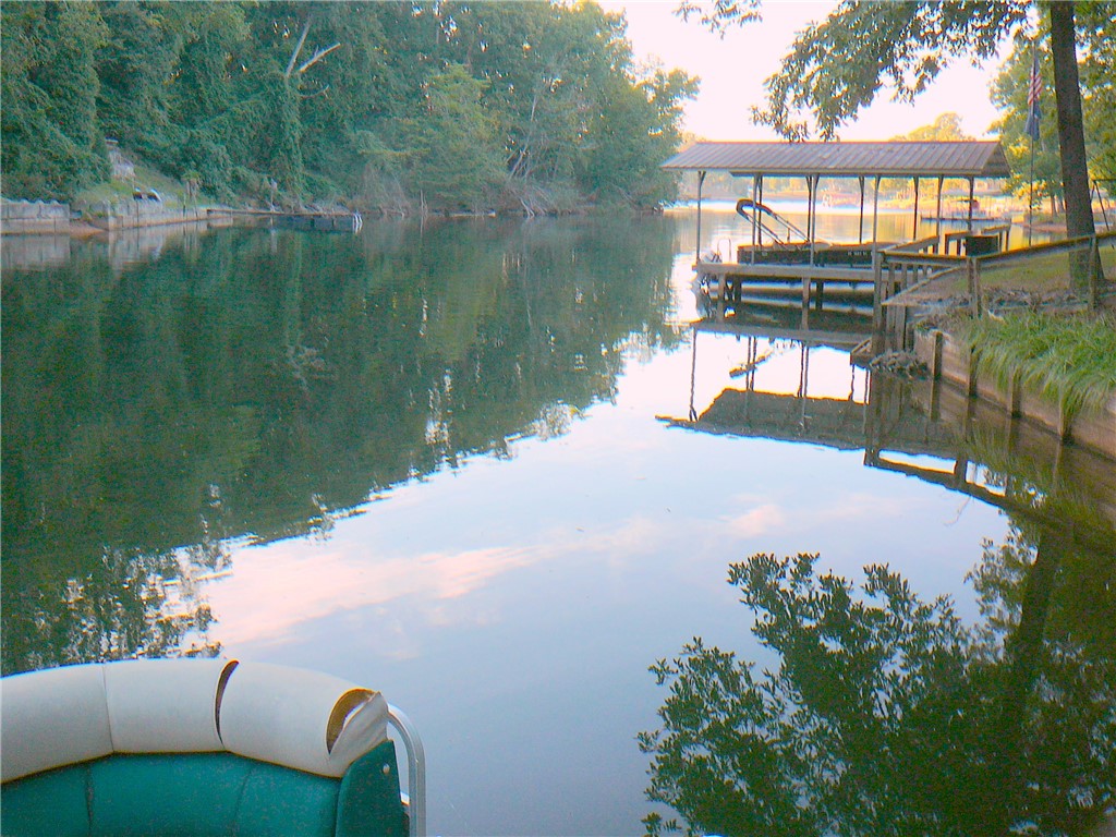 88 Catfish Cove Road Abbeville, SC 29620 - Photo 5 of 5 Calm waters reflect a covered private dock nestled along a mature, tree-lined shoreline.