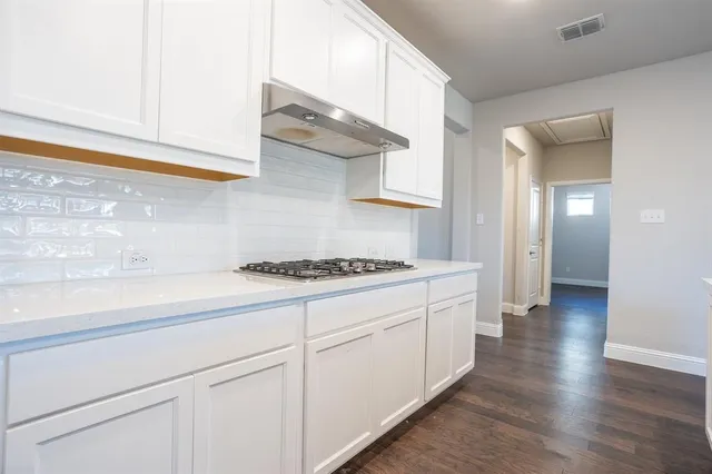 a kitchen with sink stove and cabinets