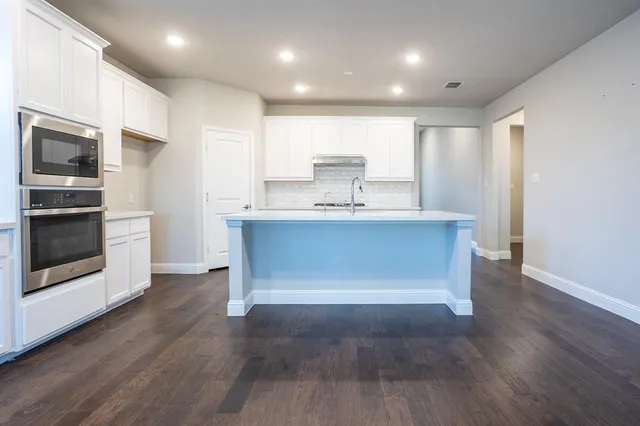 an empty room with wooden floor ceiling fan and window