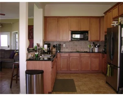 a kitchen with a refrigerator and a stove top oven