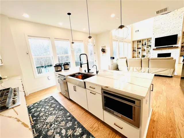 a kitchen with stainless steel appliances kitchen island granite countertop a stove a sink and a microwave