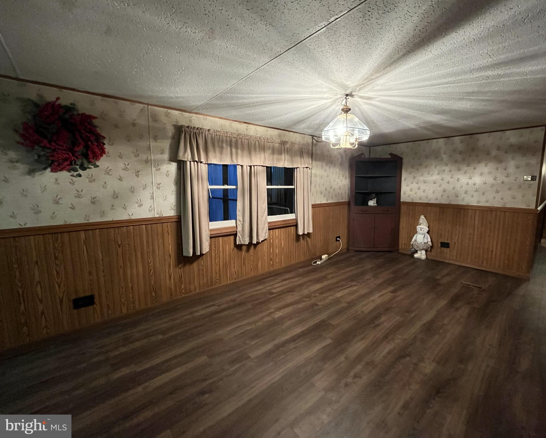 512 Brosius Hill Road Mount Pleasant Mills, PA 17853 - Photo 11 of 59 an empty room with wooden floor chandelier fan and windows