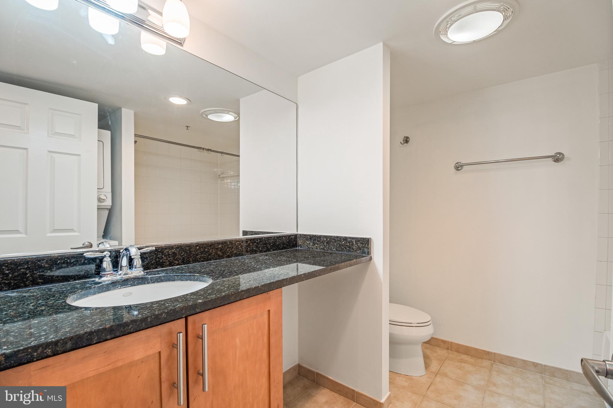 3401 38th Street Northwest, Unit 324 Washington, DC 20016 - Photo 14 of 23 a bathroom with a granite countertop sink and a mirror
