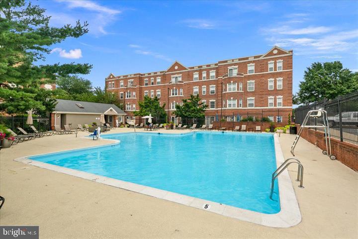 3401 38th Street Northwest, Unit 324 Washington, DC 20016 - Photo 22 of 23 a view of swimming pool with outdoor seating and a garden