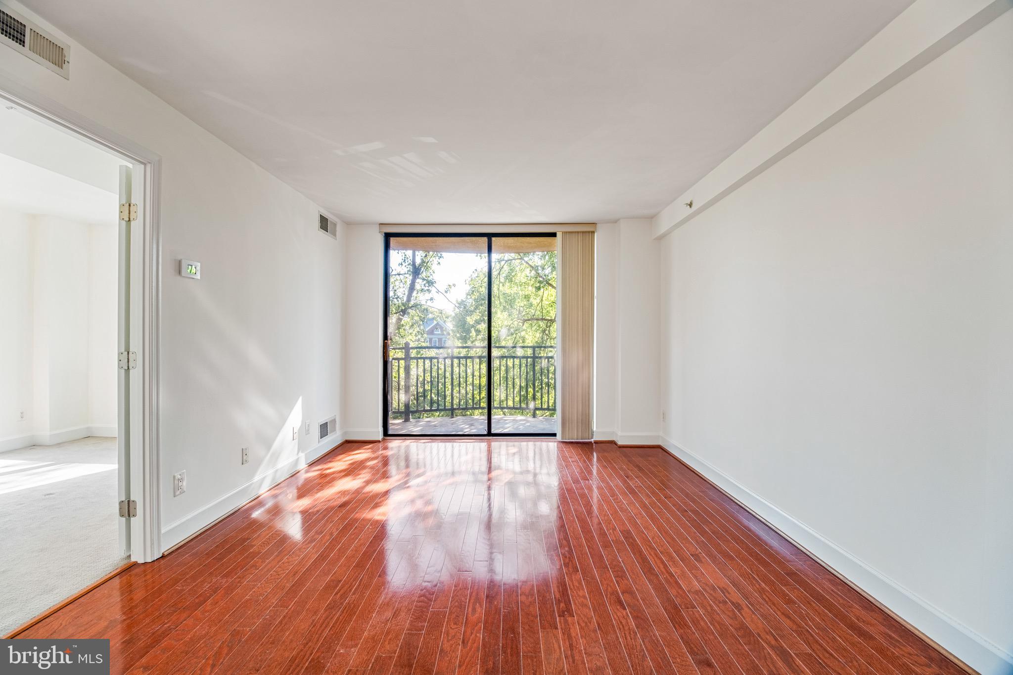 3401 38th Street Northwest, Unit 324 Washington, DC 20016 - Photo 5 of 23 a view of an empty room with wooden floor and a window