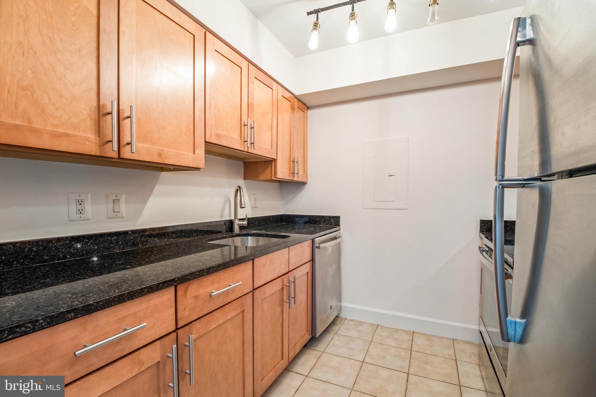 3401 38th Street Northwest, Unit 324 Washington, DC 20016 - Photo 7 of 23 a kitchen with granite countertop a refrigerator and a sink