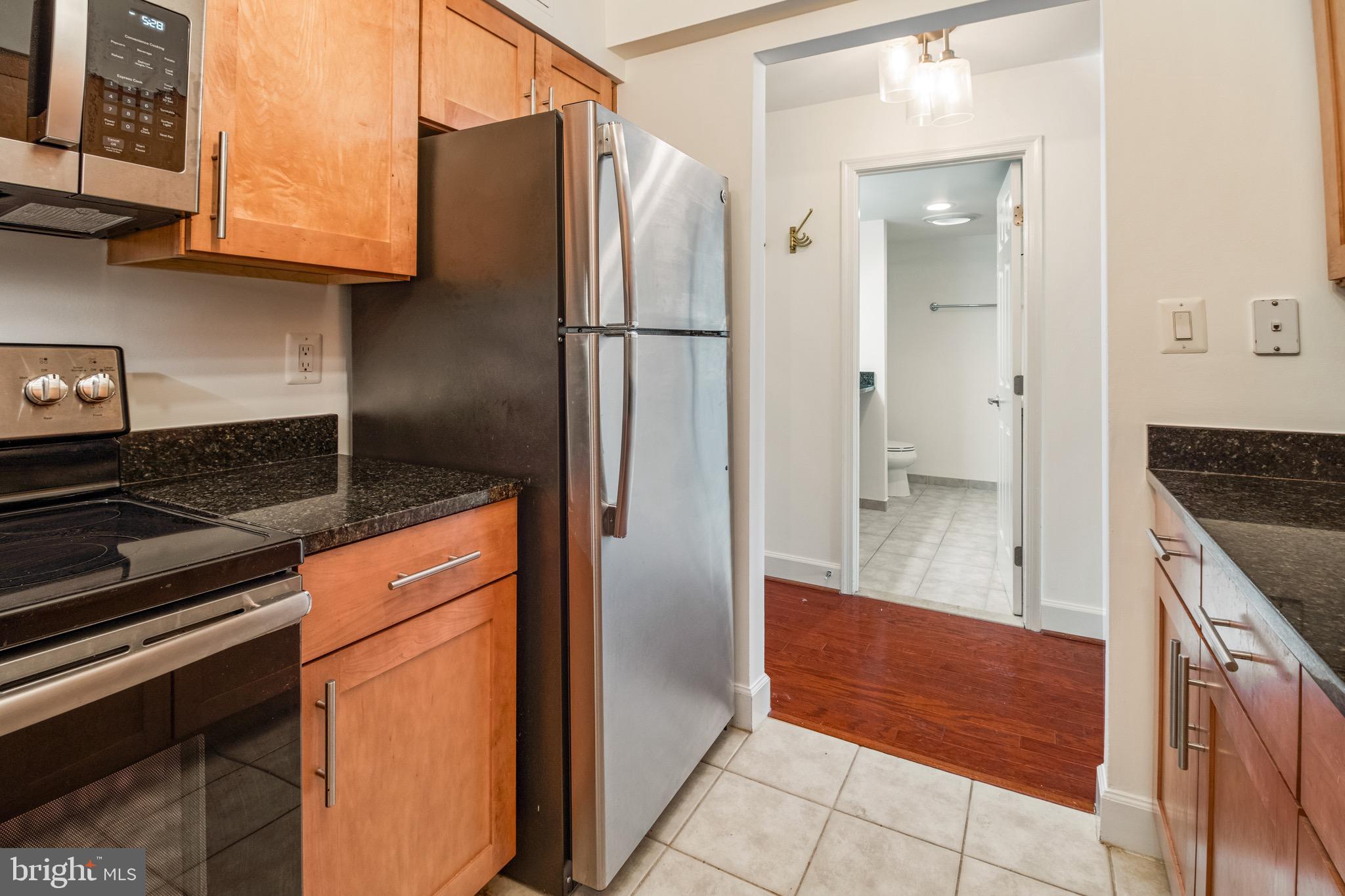 3401 38th Street Northwest, Unit 324 Washington, DC 20016 - Photo 9 of 23 a kitchen with stainless steel appliances granite countertop a refrigerator and a stove