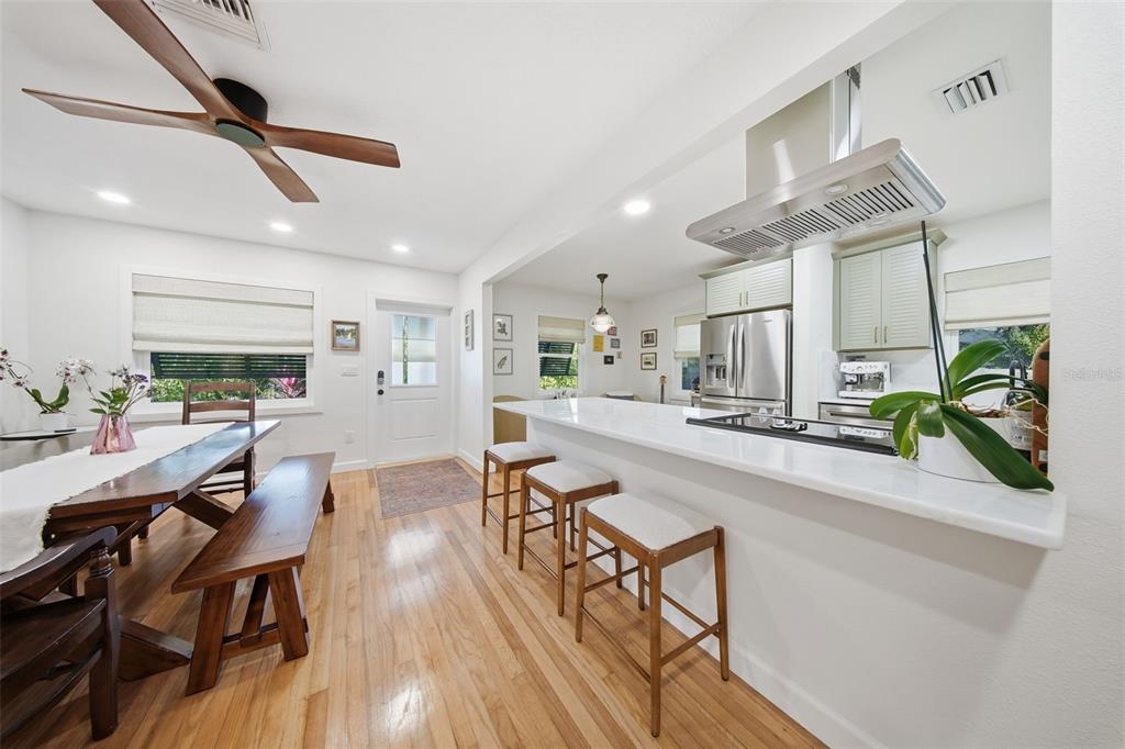 1830 Main Street Safety Harbor, FL 34695 - Photo 22 of 90 a dining room with wooden floor a chandelier a wooden table and chairs