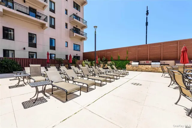 a view of a patio with couches and chairs under an umbrella
