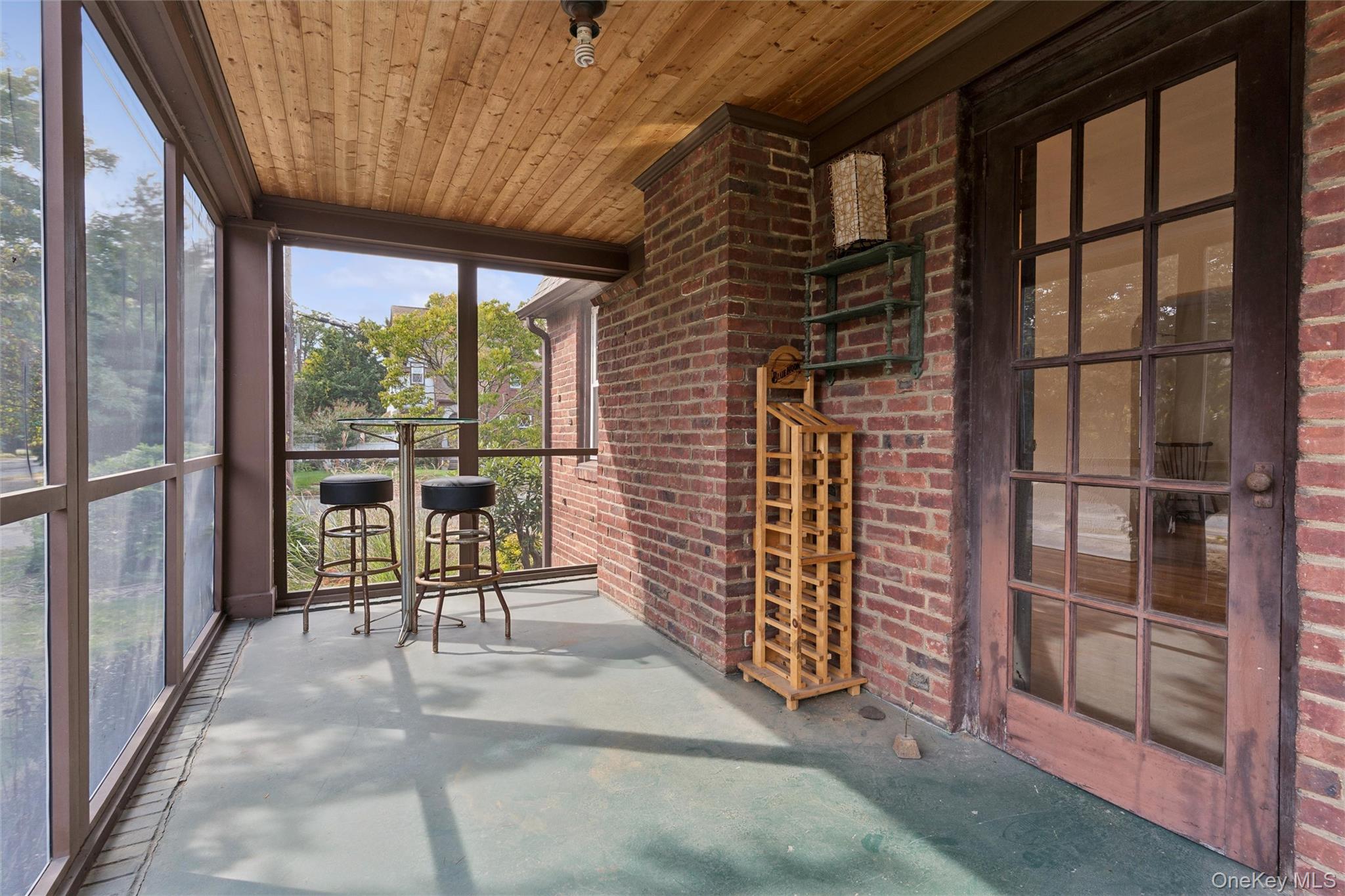 9 Troy Place Merrick, NY 11566 - Photo 14 of 23 a view of a porch with chairs and floor to ceiling window