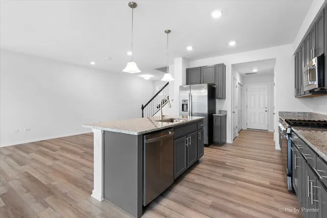 a kitchen with stainless steel appliances granite countertop a stove and a refrigerator