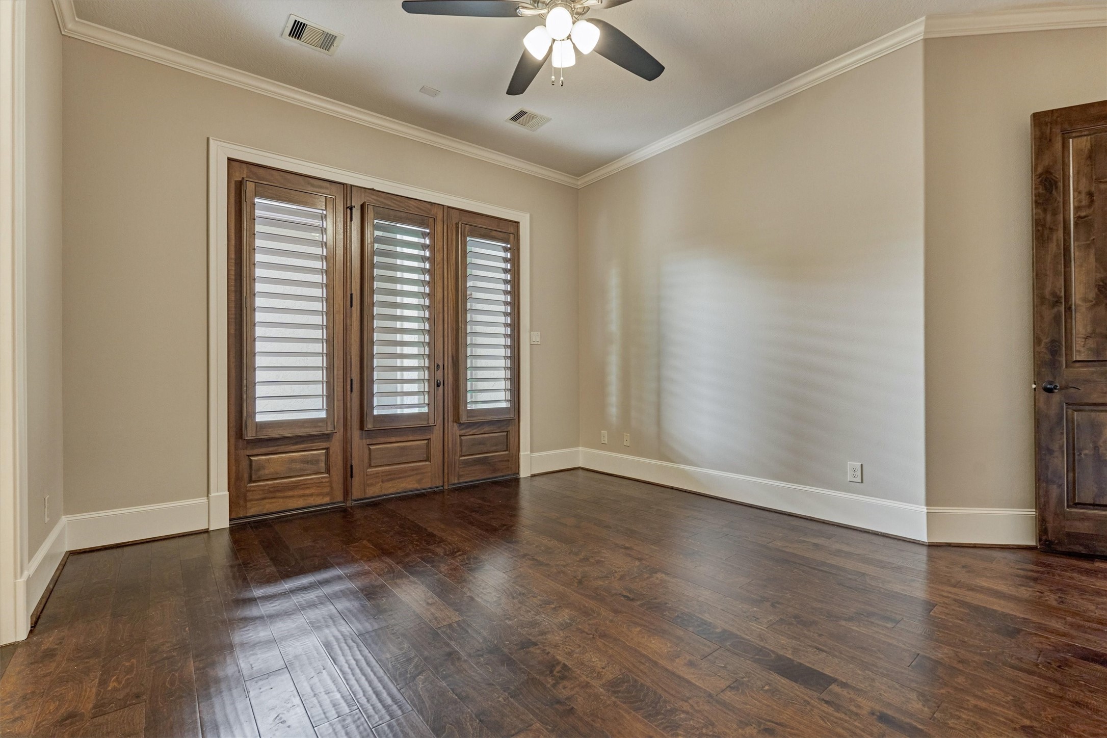 25 Post Shadow Estate Drive Spring, TX 77389 - Photo 30 of 49 Sunlit bedroom showcases rich hardwood floors, plantation shutters, crown molding, and a ceiling fan.