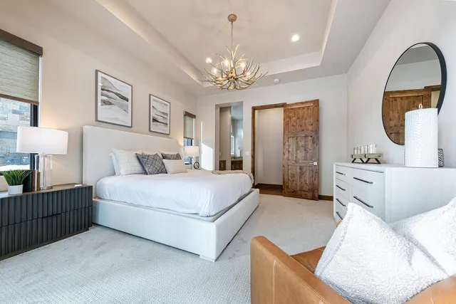 a spacious bedroom with a bed mirror and window