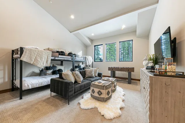 a living room with furniture flat screen tv and large window