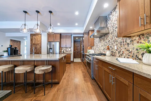 a large kitchen with kitchen island granite countertop lots of counter space and windows