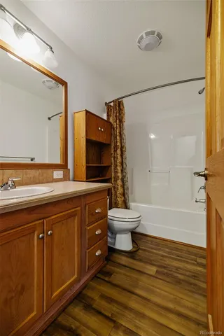 a spacious bathroom with a sink a toilet a mirror and bathtub
