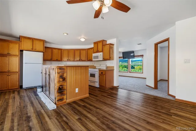 a kitchen with stainless steel appliances granite countertop a refrigerator a stove and a wooden floors