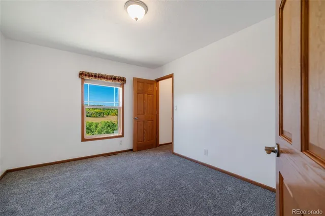 an empty room with windows and mirror