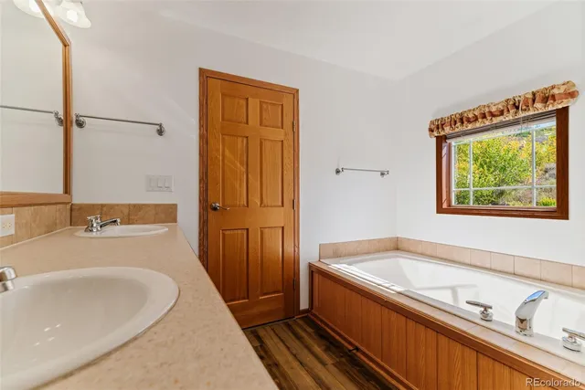 a bathroom with a tub sink and mirror