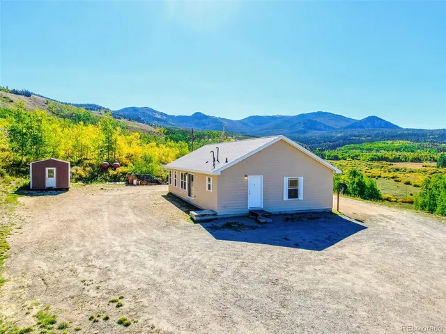 a view of a house with a yard and large tree