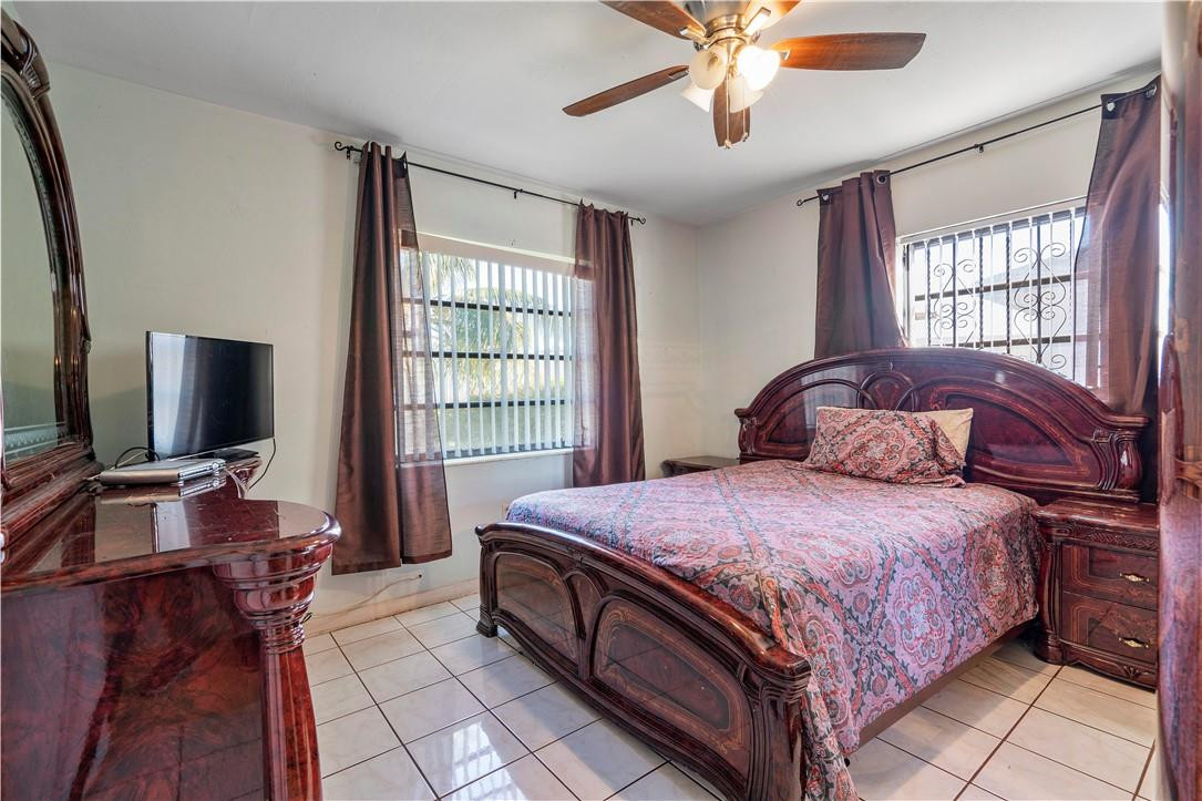 Undisclosed Address Miami, FL 33169 - Photo 17 of 24 a bedroom with a bed and a chandelier