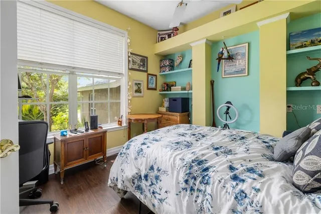 a bedroom with a bed and wooden floor
