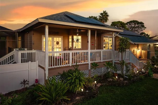a view of a house with a small yard and deck