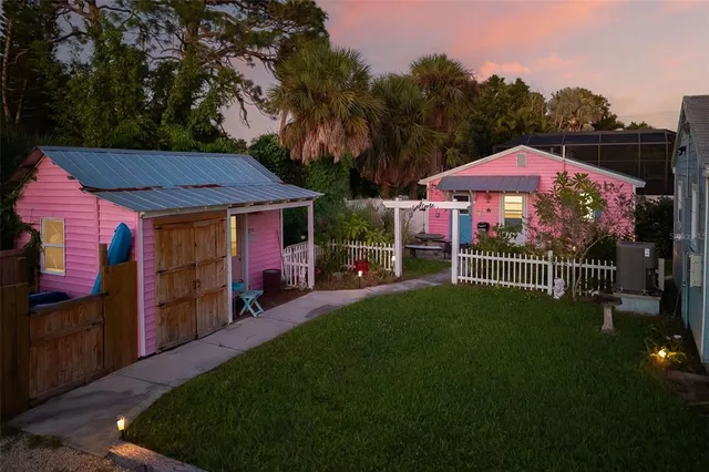 a view of a house with a yard potted plants and a bench