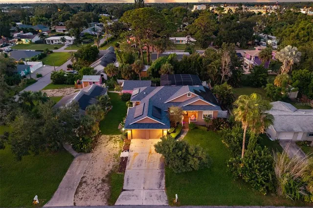 an aerial view of residential houses with outdoor space and trees