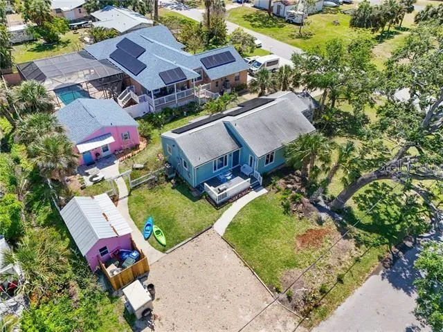 an aerial view of a house with a yard and tennis court
