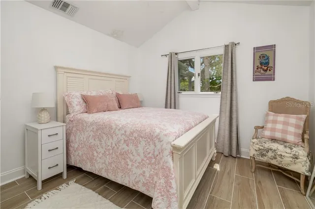 a bedroom with a bed and wooden floor