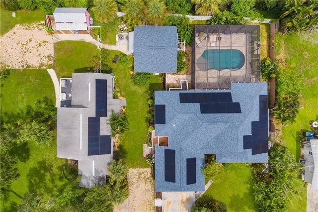 an aerial view of a house with a swimming pool and outdoor seating