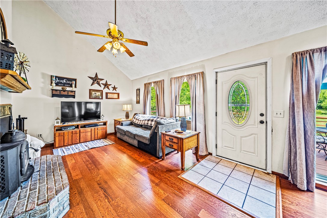 4460 Tower Road Dorset, OH 44032 - Photo 6 of 45 Foyer featuring a textured ceiling, ceiling fan, hardwood / wood-style floors, and a wood stove
