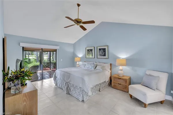 a spacious bedroom with a bed and a potted plant