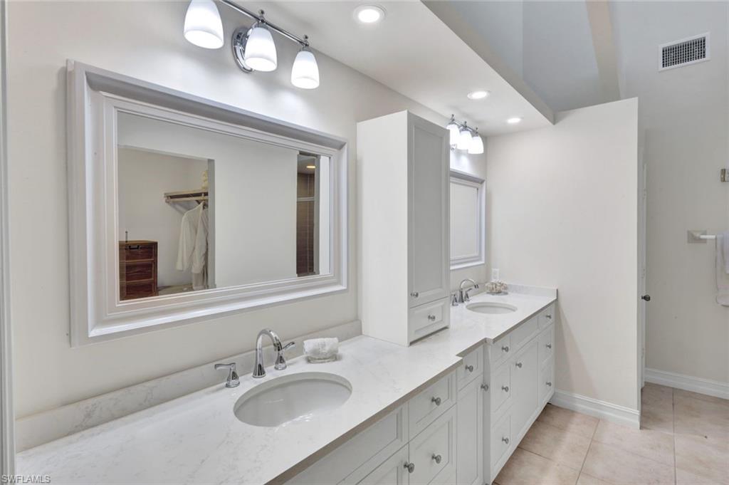 202 Bears Paw Trail, Unit 97 Naples, FL 34105 - Photo 17 of 28 a bathroom with double vanity sink and a mirror