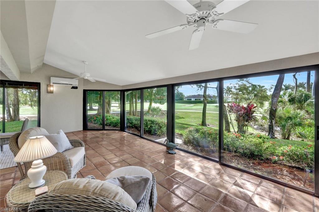 202 Bears Paw Trail, Unit 97 Naples, FL 34105 - Photo 22 of 28 a view of a livingroom with furniture wooden floor and a floor to ceiling window