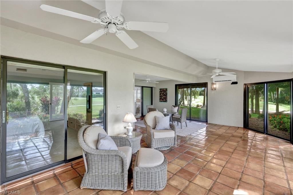 202 Bears Paw Trail, Unit 97 Naples, FL 34105 - Photo 23 of 28 a living room with patio furniture and a floor to ceiling window