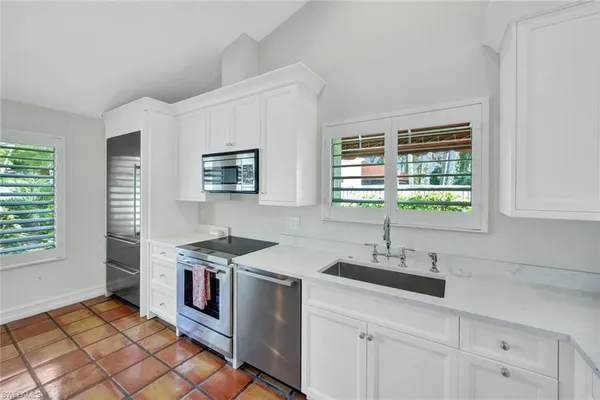 a kitchen with stainless steel appliances granite countertop a sink stove and cabinets
