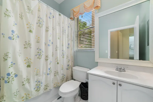a bathroom with a sink a toilet and shower curtain