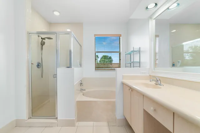 a bathroom with a tub sink shower and mirror