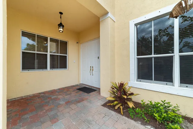 a view of a house with a window and potted plants