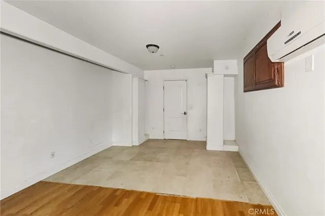 a view of a big room with wooden floor and entryway