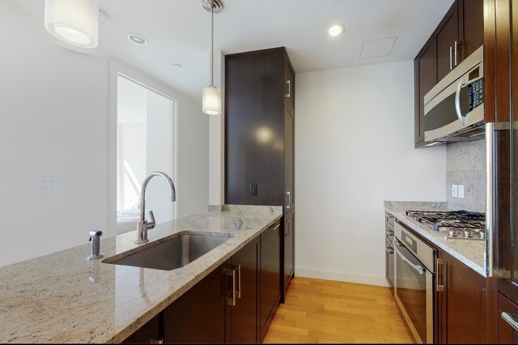 400 Stuart Street, Unit 18G Boston, MA 02116 - Photo 7 of 20 a kitchen with stainless steel appliances granite countertop a sink a stove and a refrigerator