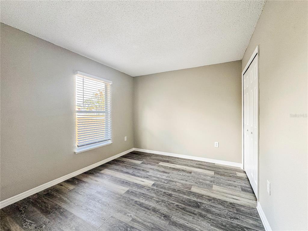 Undisclosed Address Spring Hill, FL 34609 - Photo 11 of 18 an empty room with wooden floor and windows