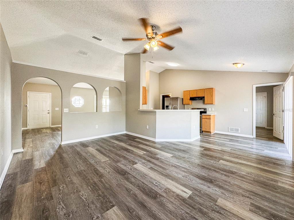 Undisclosed Address Spring Hill, FL 34609 - Photo 4 of 18 a view of a kitchen with wooden floor and a ceiling fan