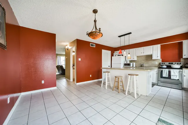 a kitchen with white cabinets and appliances