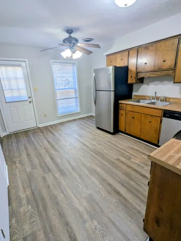 a kitchen with granite countertop a refrigerator and a sink