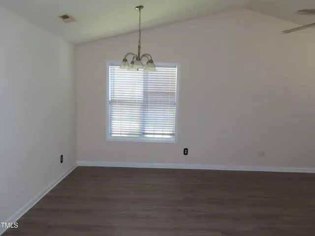 a view of a room with a window a ceiling fan and wooden floor