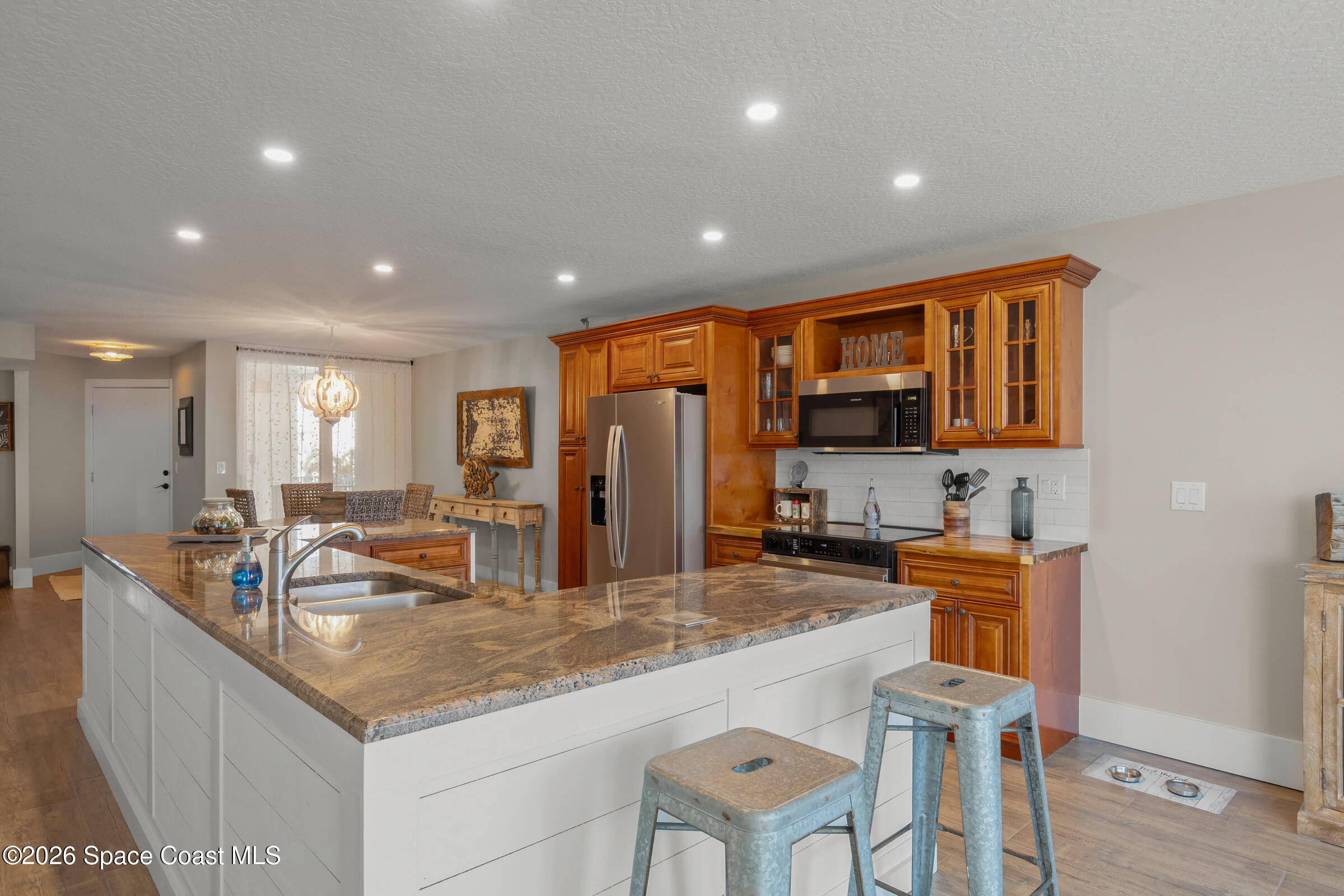 700 Wave Crest Avenue, Unit 206 Indialantic, FL 32903 - Photo 15 of 36 a kitchen with granite countertop a sink and cabinets